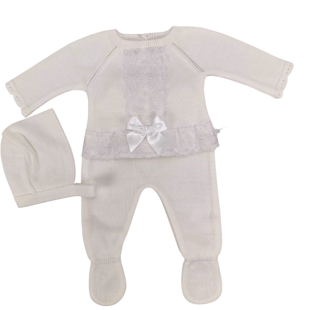 Conjunto de bebé color marfil en tejido punto con detalles de encaje y lazo, incluye pantalón con pie y gorro a juego.