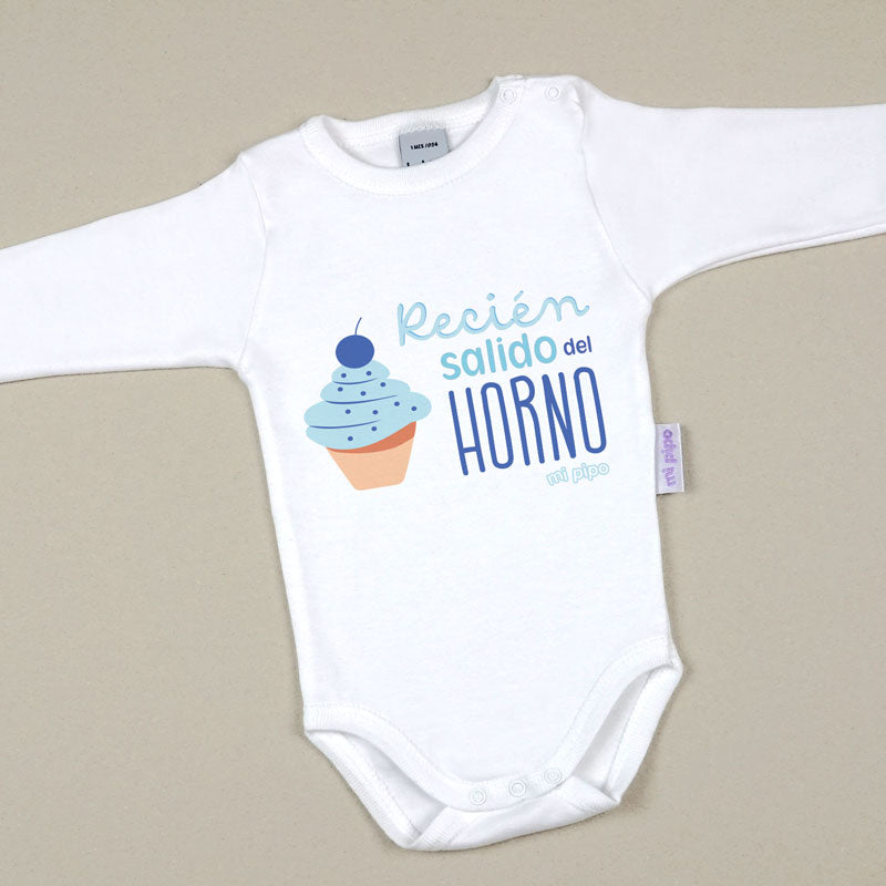 Body blanco de manga larga para bebé con diseño de cupcake azul y texto “Recién salido del horno”.