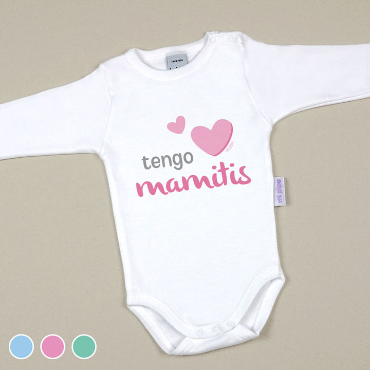 Body blanco de bebé manga larga con texto "tengo mamitis" y corazones rosas en el pecho.