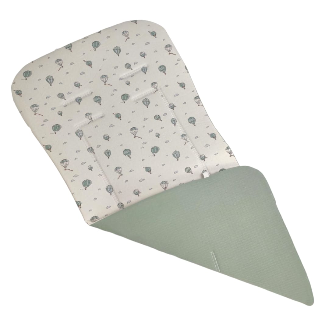 Colchoneta rectangular reversible con un lado verde menta liso y el otro blanco con estampado de globos aerostáticos en.