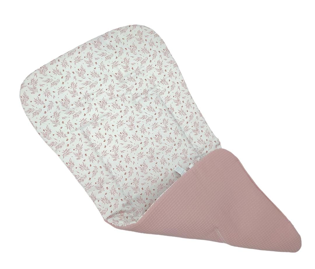 Colchoneta reversible para bebé con diseño de espigas, tela rosa sólido y estampado floral rosa sobre fondo blanco.