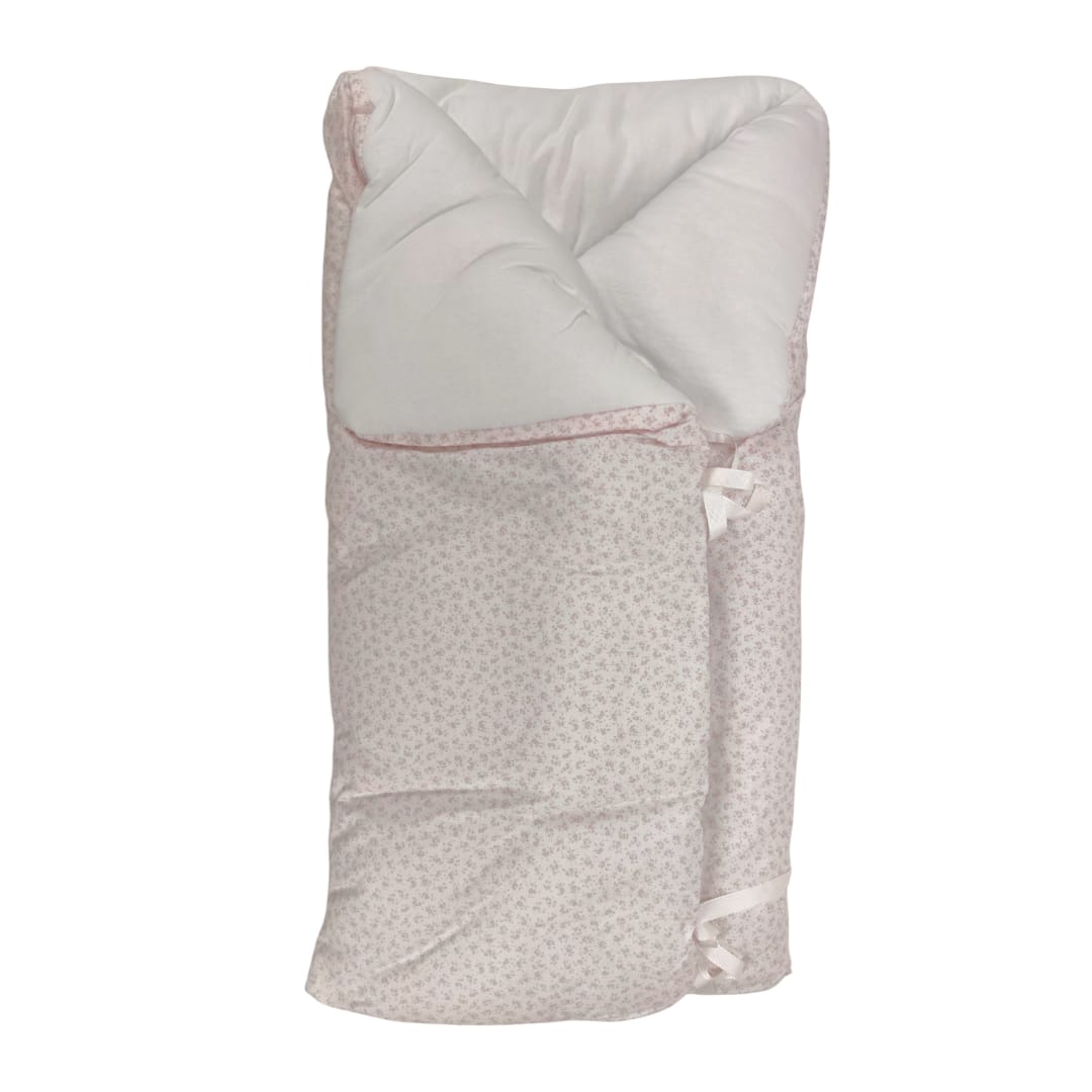 Saco manta para capazo beige con estampado de florecitas rosas y interior acolchado blanco.