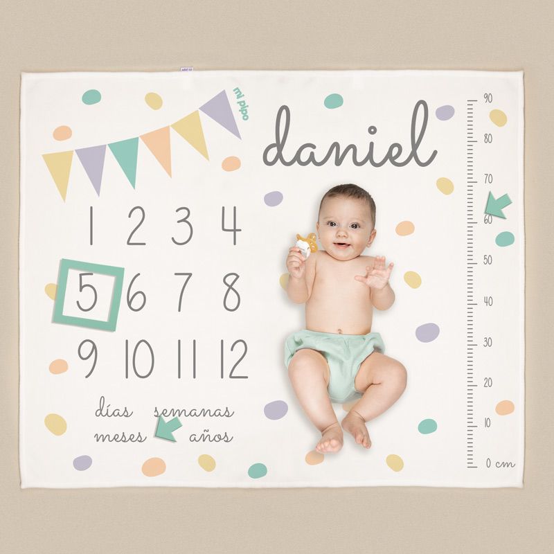 Manta blanca con banderines de colores pastel, números del 1 al 12, nombre "daniel" personalizado y regla lateral para medir