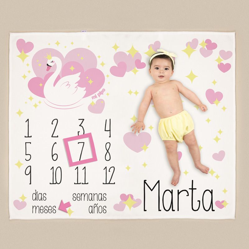 Manta blanca con diseño de cisne rosa, corazones y estrellas, números para marcar meses y espacio para bebé con nombre Marta.