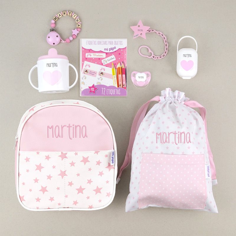 Mochila rosa con estrellas y nombre personalizado, bolsita y set con chupete, broche, taza y cadenita de madera rosa.