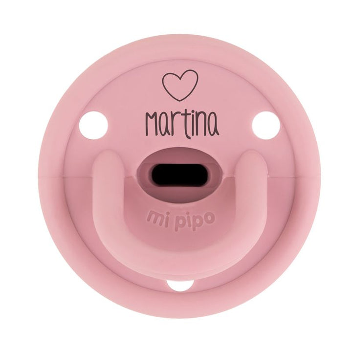 Chupete rosa con diseño de corazón negro y nombre "Martina" en el centro, material suave de silicona.