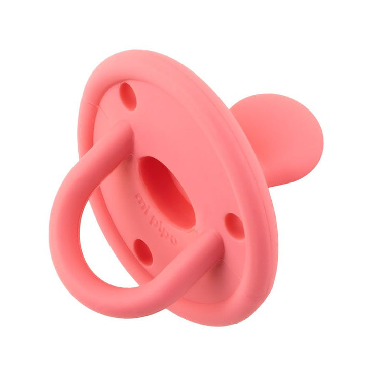 Chupete de silicona rosa con diseño ergonómico y anilla para sujetar, en forma clásica.
