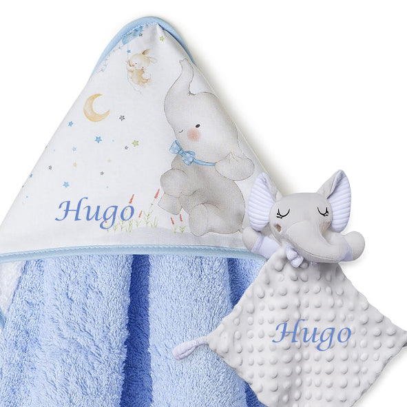 Capa de baño azul con capucha blanca bordada con osito y nombre Hugo, doudou elefante gris personalizado.